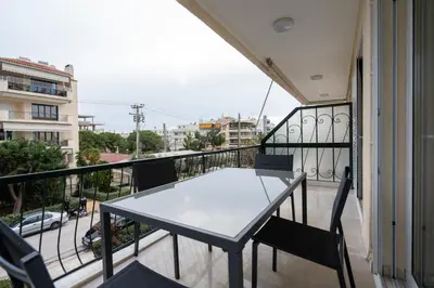 a table and chairs on a balcony with a view at Relaxing Voula Hideaway in Athens