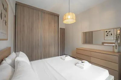 a bedroom with a white bed and a mirror at Relaxing Voula Hideaway in Athens