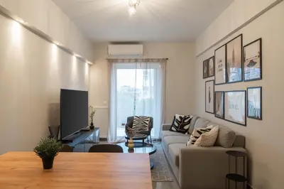 a living room with a couch and a tv at Relaxing Voula Hideaway in Athens