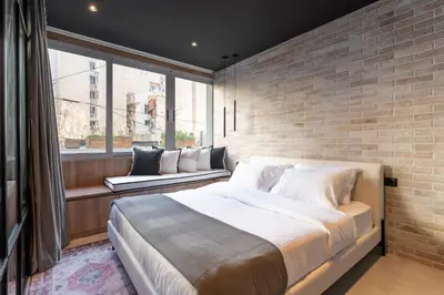 a bedroom with a large bed and a brick wall at Acropolis Industrial Loft in Athens