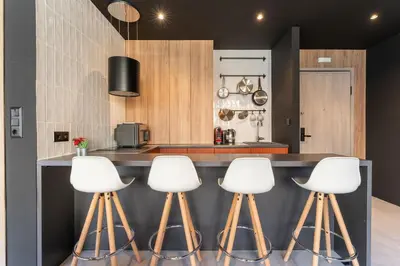 a kitchen with white stools at a counter at Acropolis Industrial Loft in Athens