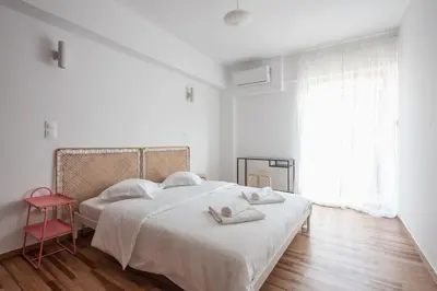 a white bedroom with a bed with towels on it at Zen Bright, Exarchia in Athens