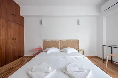 a bedroom with a white bed with three white pillows at Zen Bright, Exarchia in Athens