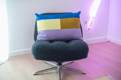 a chair with a colorful pillow on top of it at Zen Bright, Exarchia in Athens