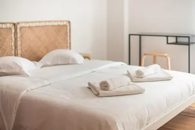 a white bed with towels on top of it at Zen Bright, Exarchia in Athens