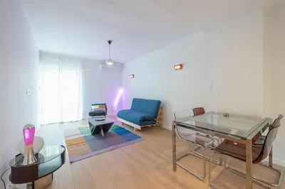 a living room with a glass table and a blue couch at Zen Bright, Exarchia in Athens