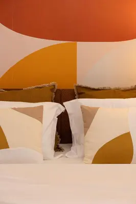 a bed with white pillows and a colorful wall at Retro-Modern Echoes in Athens