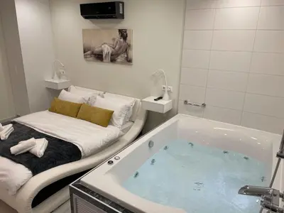 a bathroom with a bath tub with a bed at Bubble & Relax- Private Jacuzzi Near Acropolis- Fix Metro 180m in Athens