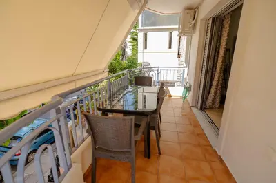 a balcony with a glass table and chairs at Ηappy Apartment 1 in Athens