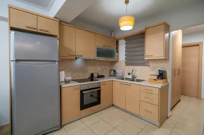 a kitchen with wooden cabinets and a stainless steel refrigerator at Ηappy Apartment 1 in Athens
