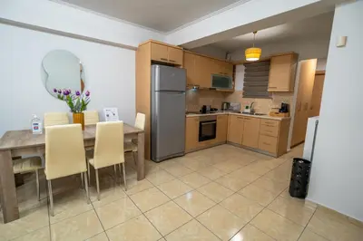 a kitchen with a table with chairs and a refrigerator at Ηappy Apartment 1 in Athens