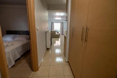 a bedroom with a bed and a door to a hallway at Ηappy Apartment 1 in Athens