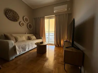 a living room with a couch and a television at BFC Glufada in Athens