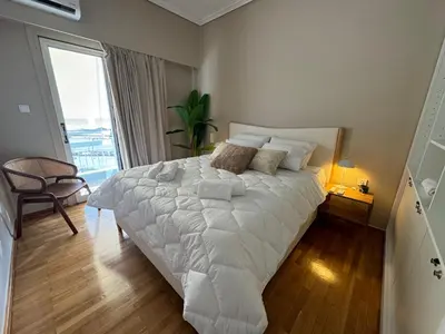 a large white bed in a room with a window at BFC Glufada in Athens