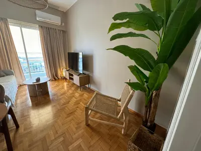a living room with a chair and a plant at BFC Glufada in Athens