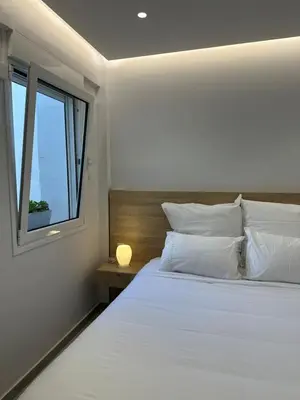 a bedroom with a large white bed with a window at Stylish Apartment in the Heart of Athens in Athens