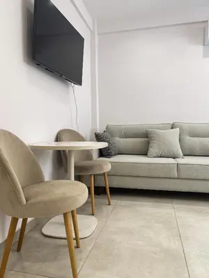 a living room with a couch and a table and chairs at Stylish Apartment in the Heart of Athens in Athens
