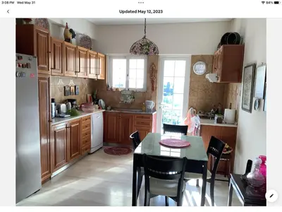 a kitchen with wooden cabinets and a table and chairs at Sunshine place in Glyfada in Athens