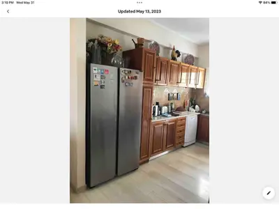 a kitchen with a stainless steel refrigerator and wooden cabinets at Sunshine place in Glyfada in Athens