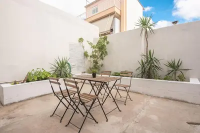 a table and chairs on a patio with plants at apartment10minutesfrommonastiraki in Athens