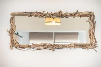 a mirror made out of driftwood on a wall at apartment10minutesfrommonastiraki in Athens