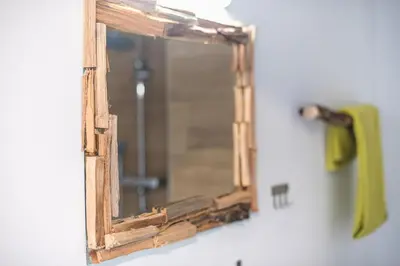a mirror on a wall with a green towel at apartment10minutesfrommonastiraki in Athens
