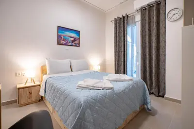 a bedroom with a bed and a window with a clock at City Center Studio for 2 by MPS in Athens