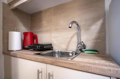 a kitchen sink with a red appliance on a counter at City Center Studio for 2 by MPS in Athens