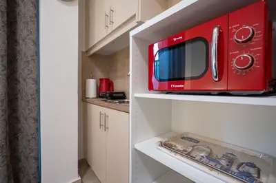a red microwave sitting on a shelf in a kitchen at City Center Studio for 2 by MPS in Athens