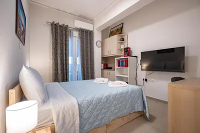 a bedroom with a bed and a flat screen tv at City Center Studio for 2 by MPS in Athens