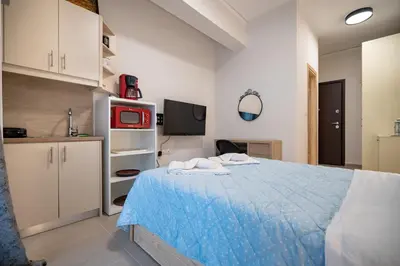 a bedroom with a blue bed and a tv at City Center Studio for 2 by MPS in Athens