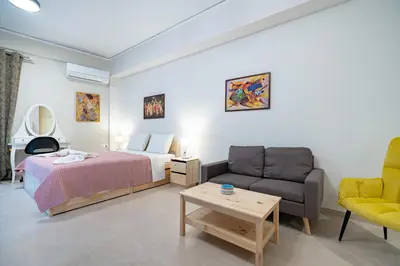 a bedroom with a bed and a couch and a table at Comfy Studio with private terrace by MPS in Athens