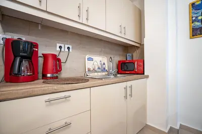 a kitchen with a red coffee maker and a microwave at Comfy Studio with private terrace by MPS in Athens