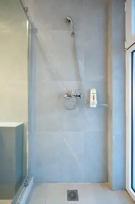 a bathroom with a shower with a glass door at Comfy Studio with private terrace by MPS in Athens