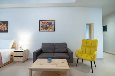a living room with a couch and a chair at Comfy Studio with private terrace by MPS in Athens