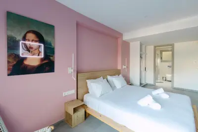 a bedroom with two beds and a painting on the wall at 11 Reasons Why Metaxourgeio in Athens