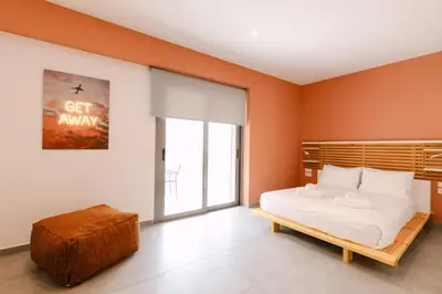 a bedroom with orange walls and a bed and a window at 11 Reasons Why Metaxourgeio in Athens
