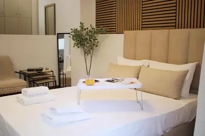 a white bed with a table with towels on it at ARIS- The Urban Retreat in Athens