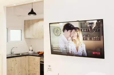 a kitchen with a flat screen tv on a wall at ARIS- The Urban Retreat in Athens