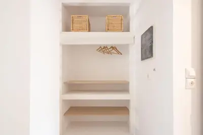 a hallway with white shelves and wicker baskets at studio3 - -10-minutes-from-Monastiraki-Athens! in Athens