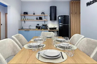 a dining room with a table with chairs and a refrigerator at Dione Elegant Apartment Near Acropolis in Athens