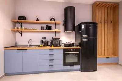 a kitchen with a black refrigerator and a sink at Dione Elegant Apartment Near Acropolis in Athens