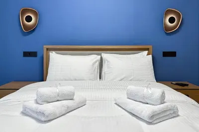 a white bed with two towels on top of it at Dione Elegant Apartment Near Acropolis in Athens