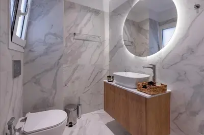 a white bathroom with a sink and a mirror at Dione Elegant Apartment Near Acropolis in Athens