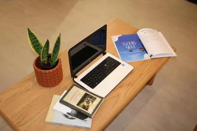 a table with a laptop computer and a book at ARIS Petralona in Athens
