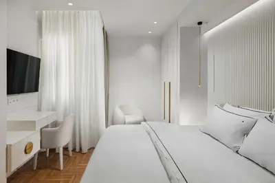 a white bedroom with a bed and a desk at 4bd Ensuite Luxury Residence Kolonaki in Athens