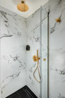 a bathroom with a shower with white marble walls at 4bd Ensuite Luxury Residence Kolonaki in Athens