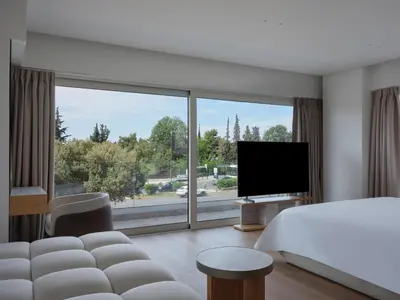 a hotel room with a bed and a large window at Nur Riviera Aparthotel in Athens