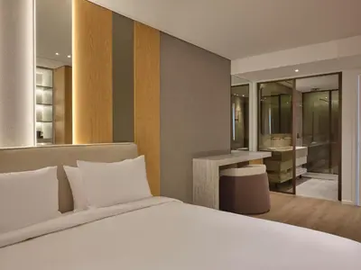 a bedroom with a white bed and a bathroom at Nur Riviera Aparthotel in Athens