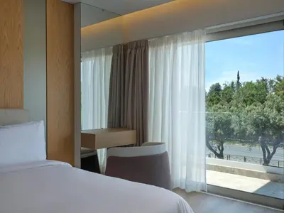 a hotel room with a bed and a large window at Nur Riviera Aparthotel in Athens